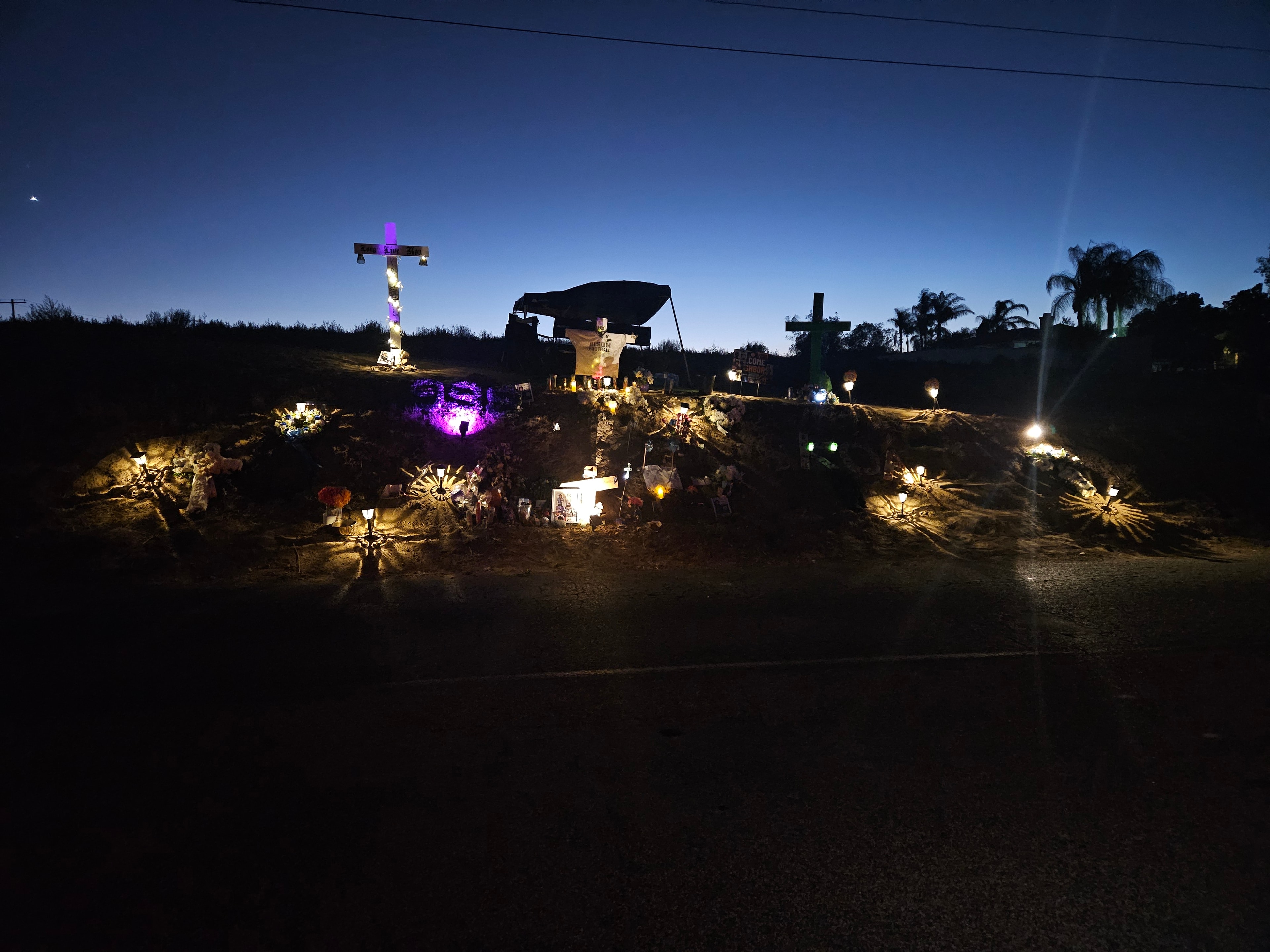 Memorial for Koa — candles and flowers at night